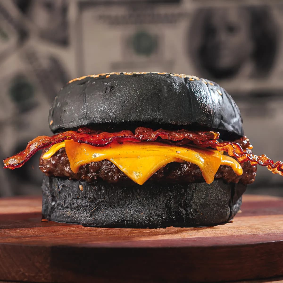 Renda Passiva: burger de pão preto com blend de 150g, cheddar derretido e bacon